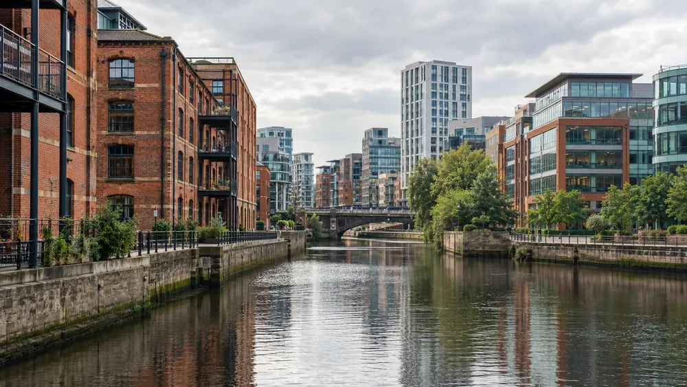 Red brick commercial buildings and modern offices beside the River Aire in Leeds